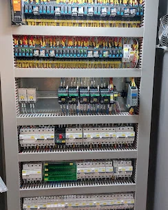 Filas de componentes elétricos e cablagem no interior de um quadro